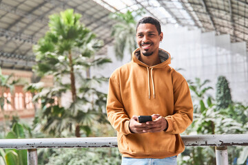Young man using smartphone inside train station