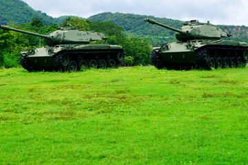 Military Tanks on Green Grass Field Surrounded by Hills and Trees