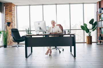 Successful businesswoman working in an elegant corporate office environment surrounded by modern...
