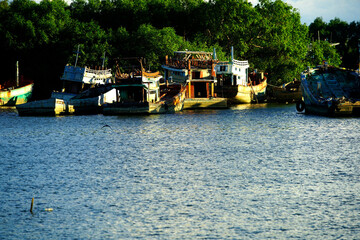 Fototapeta premium Colorful fishing boats resting peacefully by the tranquil riverbank