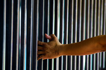 Hand Reaching Towards Vertical Metal Bars in Natural Light Setting
