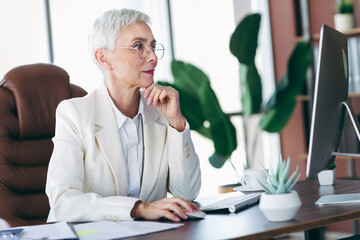 Confident senior businesswoman working in a professional office environment wearing an elegant...