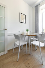 Bright Dining Nook with White Chairs and Wooden Floor