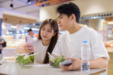 Young couple eating salad in restaurant