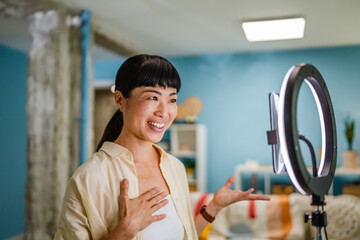 Smiling female Japanese video blogger record new video for subscribers