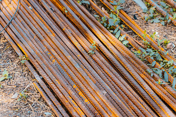 Steel rods bars, Metal, and Iron reinforcement lying on the ground on the construction site for material used for reinforcing concrete building construction. Concept background textured architecture