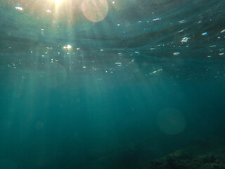 The sun shines through water, casting mottled light and shadow, intertwined with countless bubbles...