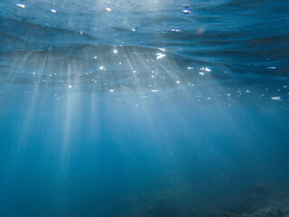 The sun shines through water, casting mottled light and shadow, intertwined with countless bubbles...