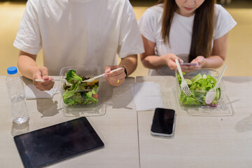 Young couple eating salad in restaurant