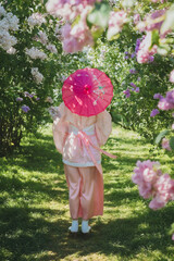 Dreamy portrait of a mysterious geisha-cosplay inspired beauty. Porcelain-skinned woman in a pink...