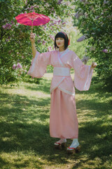 Dreamy portrait of a mysterious geisha-cosplay inspired beauty. Porcelain-skinned woman in a pink...