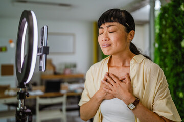 Smiling female Japanese video blogger record new video for subscribers