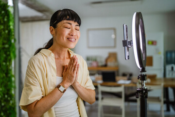 Smiling female Japanese video blogger record new video for subscribers