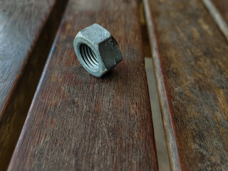 close up of a nut bolt on a wooden bench