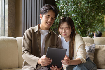 Couple using tablet computer in cafe while having coffee