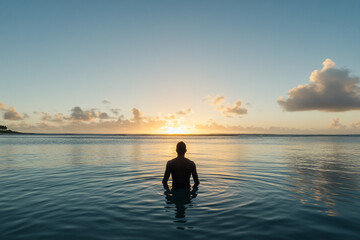 Fototapeta premium Person steps into the ocean at sunrise embracing tranquility