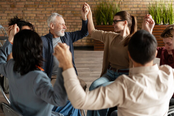 Diverse group of people joining hands together in a circle
