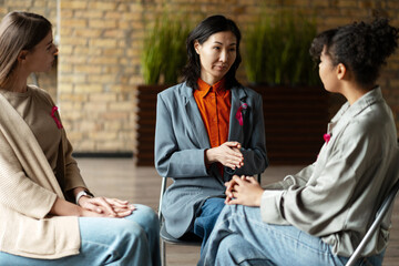 Women supporting each other during breast cancer awareness meeting