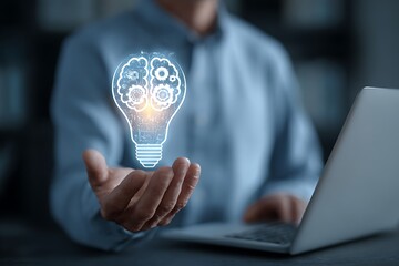 High quality photo of businessman holding a virtual light bulb with brain and gears icon on a laptop screen, symbolizing innovative ideas for business growth in digital marketing.