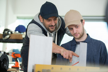 two workers in a carpenters workshop