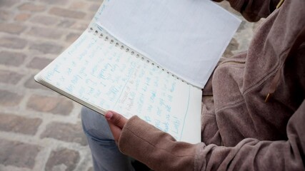 Camera shows creative scribbles as kid studies book from behind viewpoint