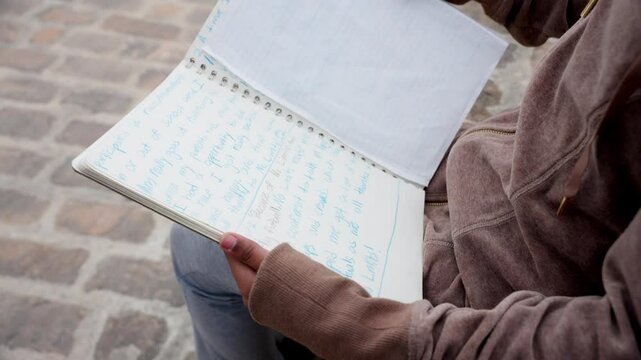 Camera shows creative scribbles as kid studies book from behind viewpoint