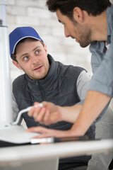 close-up of apprentice and teacher fixing a chair