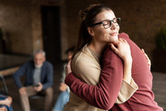 Woman is hugging a man during group therapy session