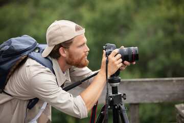 closeup of young hipster man with digital camera outdoors