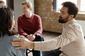 Psychotherapist comforting patient during group therapy session