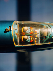 Close-up of a vintage toy vehicle cockpit with two illustrated robot pilots under a transparent plastic canopy, showcasing retro colors and mechanical interior details