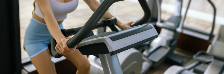 Attractive young woman at the gym riding on spinning bike. Healthy Lifestyle and Sport Concepts.