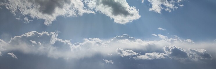 sunny dramatic blue sky with clouds and sunbeams background banner
