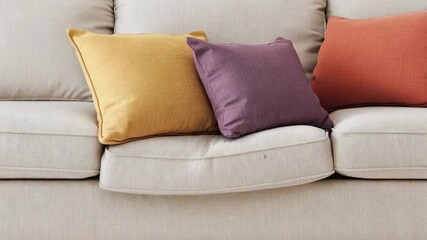 A couch with colorful pillows arranged in a unique way, perfect for home decor or lifestyle photoshoots