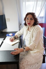 Businesswoman writing notes at her desk in office