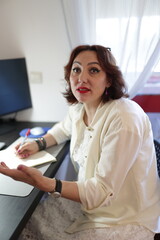 Businesswoman writing notes and gesturing during a meeting
