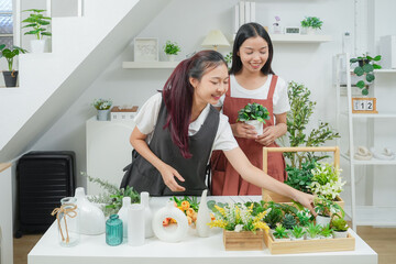 Small business. Two young asia woman florist smile arranging flowers in floral shop. Flower design store. Happiness smiling young female making flower vase for customers. 