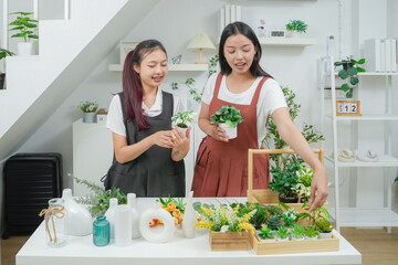 Small business. Two young asia woman florist smile arranging flowers in floral shop. Flower design store. Happiness smiling young female making flower vase for customers. 