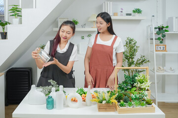 Small business. Two young asia woman florist smile arranging flowers in floral shop. Flower design store. Happiness smiling young female making flower vase for customers. 