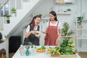 Small business. Two young asia woman florist smile arranging flowers in floral shop. Flower design store. Happiness smiling young female making flower vase for customers. 