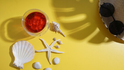 Cold refreshing beverage strawberry or cranberry ice drink, a straw hat, a sunglasses, seashells, a...
