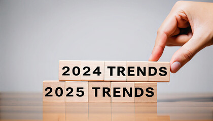 Hand placing wooden block with 2024 Trends on top of 2025 Trends
