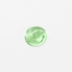 Green cosmetic gel drop on a white background