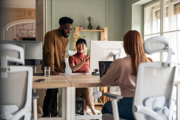 Obraz premium Diverse Team Collaborating at Workplace in a Modern Bright Office Setting