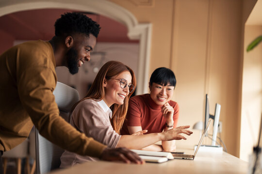Diverse Team Collaboratively Working on Creative Project in Modern Office Setting