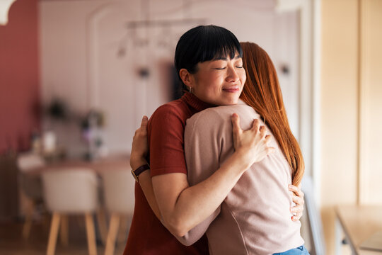 Warm Embrace Between Two Friends in a Cozy Modern Setting