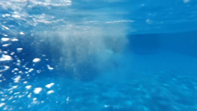 Underwater view of a pool with a disturbed surface