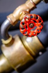 Close-up view of a vintage brass valve against a vibrant red background showcasing intricate design and craftsmanship