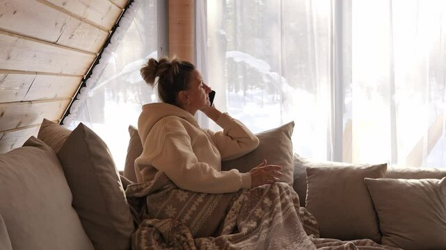 Cozy room bathed in snow light woman focused on screen unaware of snow outside her window Snow reflects contrast between inner calm and digital pull snow becomes symbol of missed presence and quiet