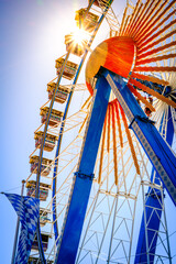 Ferris wheel illuminated at dusk with vibrant colors against a cloudy sky in a festive atmosphere